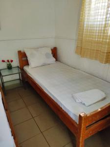 a bedroom with a wooden bed with a pillow and a window at Camping Argostoli in Argostoli