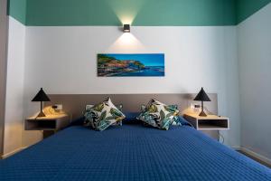 um quarto com uma cama azul e 2 candeeiros em TwoWays5Terre em La Spezia