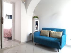 um sofá azul numa sala de estar branca em Casa Sophia em Ischia