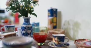 uma mesa com um copo e um vaso com uma bebida em B&b Casa Bello em Trecase