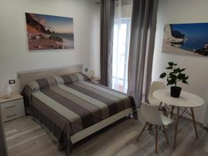 een slaapkamer met een bed en een tafel met een potplant bij Affittacamere Rosita Recanati in Recanati