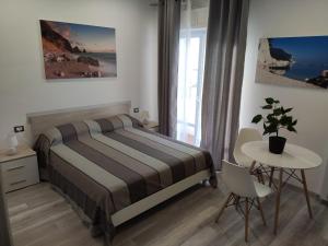 1 dormitorio con cama y mesa con maceta en Affittacamere Rosita Recanati, en Recanati