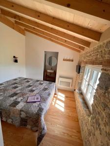a bedroom with a bed and a stone wall at LE MOULIN DU VIVIER in Saint-Martin-Lalande