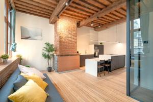 an open living room with a couch and a kitchen at The Hendrik Square Apartments in Antwerp