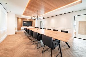 uma grande sala de conferências com uma mesa longa e cadeiras em Fasson Hotel em Heede