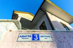 a house with a sign on top of a wall at Mini Hotel Platan in Tsandrypsh