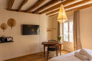 une chambre avec un lit, une table et une télévision dans l'établissement Les Nids Perchés - Rue Sainte Croix, à Mortagne-au-Perche