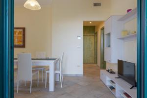 a living room with a dining room table and a television at Blue Sea - Villa Aquilone by Wonderful Italy in Ostuni