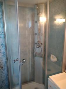 La salle de bains est pourvue d'une douche avec une porte en verre. dans l'établissement Appartement Port Rose 2, à Leucate