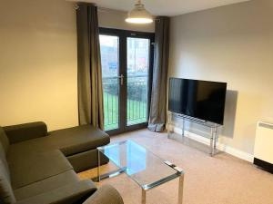 a living room with a couch and a flat screen tv at BEST PRICE! Huge 1 bed Apartment, City Centre, Single Beds or Super King, Sofabed & FREE SECURE PARKING in Southampton