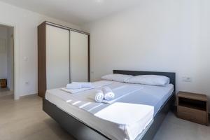 a bedroom with a large bed with towels on it at Sunset Apartment in Cres