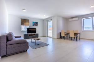 a living room with a couch and a table at Sunset Apartment in Cres