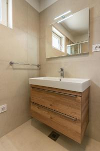 a bathroom with a sink and a mirror at Sunset Apartment in Cres +8 photos