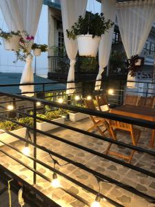 balcón con mesa, sillas y macetas en Nhà của Mỵ en Dalat
