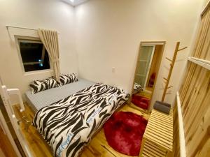 Habitación con 2 camas y almohadas de cebra. en Nhà của Mỵ en Dalat