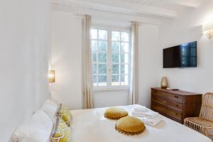 a living room with a couch and a table and a tv at Maison d'Orange - La Pinede in Saint-Tropez