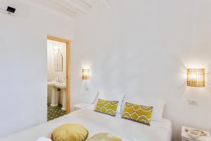 a white bedroom with a bed and a sink at Maison d'Orange - La Pinede in Saint-Tropez