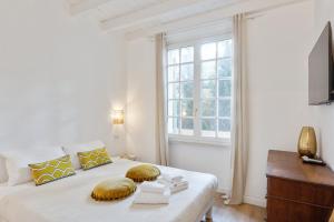 a white bedroom with a bed and a window at Maison d'Orange - La Pinede in Saint-Tropez +37 photos