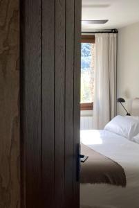 a bedroom with a bed and a window at Les Nous Hotel in Rialp