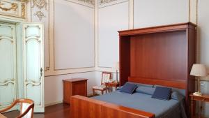 una camera con letto e testiera in legno di Hotel Grand'Italia a Padova