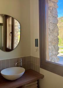 a bathroom with a white bowl sink and a mirror at Les Nous Hotel in Rialp
