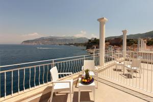 a balcony of a cruise ship with chairs and a bowl of fruit at Hotel Admiral in Sorrento