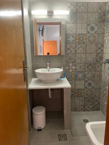 a bathroom with a sink and a mirror at Nikos Hotel in Diafani