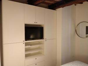 a living room with white cabinets and a tv at Isi GuestHouse 29 in Iesi