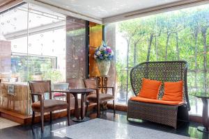 a room with chairs and a table with orange pillows at Nonthaburi Palace Hotel in Nonthaburi