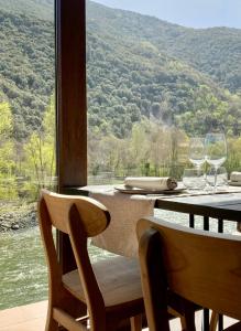 uma mesa com copos de vinho e vista para uma montanha em Les Nous Hotel em Rialp