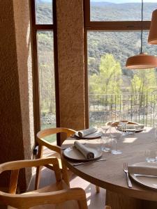 a dining table with chairs and a window with a view at Les Nous Hotel in Rialp