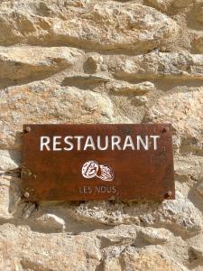 una señal en el costado de una pared de piedra en Les Nous Hotel en Rialp