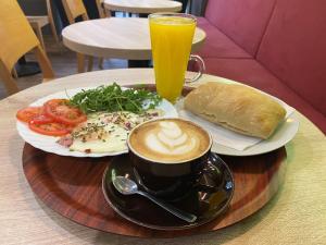 a table with a cup of coffee and a plate of food at Corvin Center Suites in Budapest