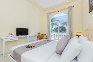 a bedroom with a large white bed and a window at Palm Villa 18 - Biệt Phủ Hướng Biển in Vung Tau