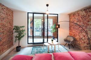 ein Wohnzimmer mit Sofa und Ziegelwand in der Unterkunft The Industrial Apartments in Antwerpen