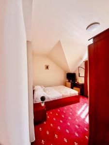 a bedroom with a bed and a red carpet at Vila Miluna in Mamaia
