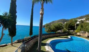 a swimming pool with a view of the ocean at Blue Charme in La Herradura