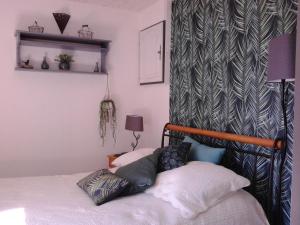 a bedroom with a bed with a headboard and a wall at Les Florides in LʼIsle-sur-la-Sorgue