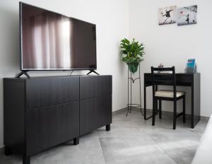 een zwarte dressoir met een flatscreen-tv bij Brand New Studio with Garage - Close to the Beach in Acquarica del Capo