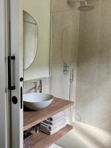 a bathroom with a sink and a shower with a mirror at Les Nous Hotel in Rialp