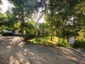 a house with a sign in front of a driveway at Clover Grange Home Stay in Matale