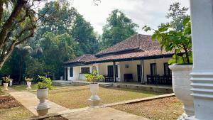 a house with two white vases in front of it at Clover Grange Home Stay in Matale