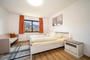 um quarto com uma cama, um sofá e uma janela em Haus Kindler em Radstadt