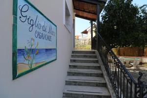 una escalera con una señal en el lateral de un edificio en Giglio di Mare en Ascea