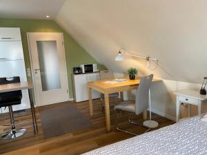 een kamer met een bureau en een tafel met een stoel bij Ferienwohnung Ausguck in Jever