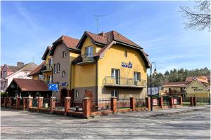 a yellow building with a fence in front of it at Willa Marlin in Pobierowo