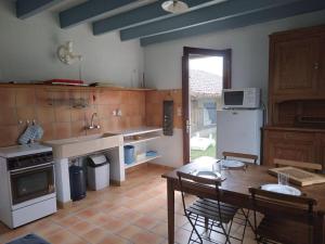a large kitchen with a table and a refrigerator at LE PETIT FROUAS SUD in Vielle-Saint-Girons