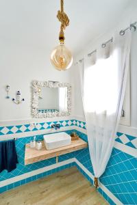y baño con lavabo y espejo. en Isola Rossa Beach House, en Isola Rossa