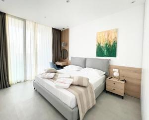 a bedroom with a large bed and a large window at Vesper Suites in Dhërmi