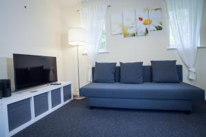 sala de estar con sofá azul y TV de pantalla plana en Central studio in quiet area, en Newbury